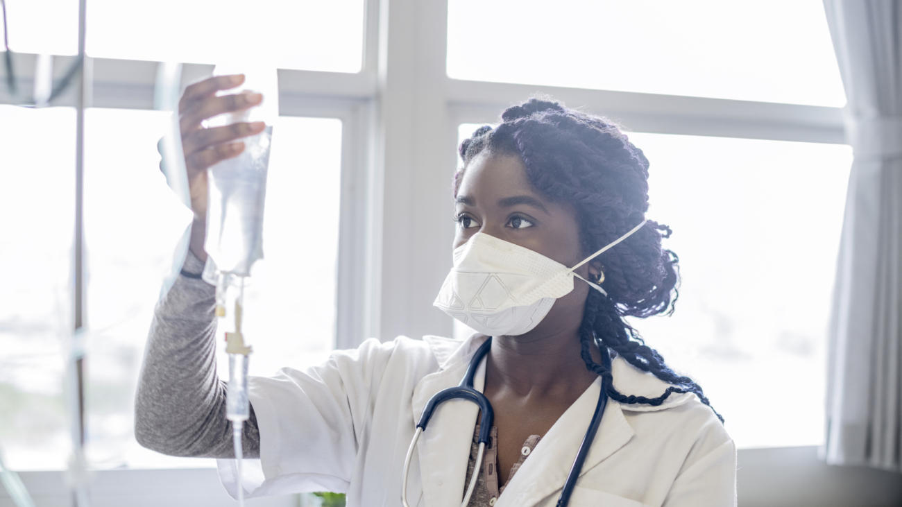 Female doctor working in hospital, holding intravenous drip, accuracy, protection, care